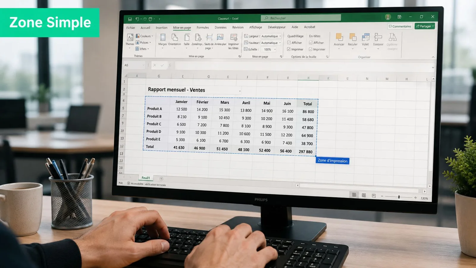 Une personne travaille sur un ordinateur affichant un tableau Excel avec une zone d'impression sélectionnée sur le bureau.